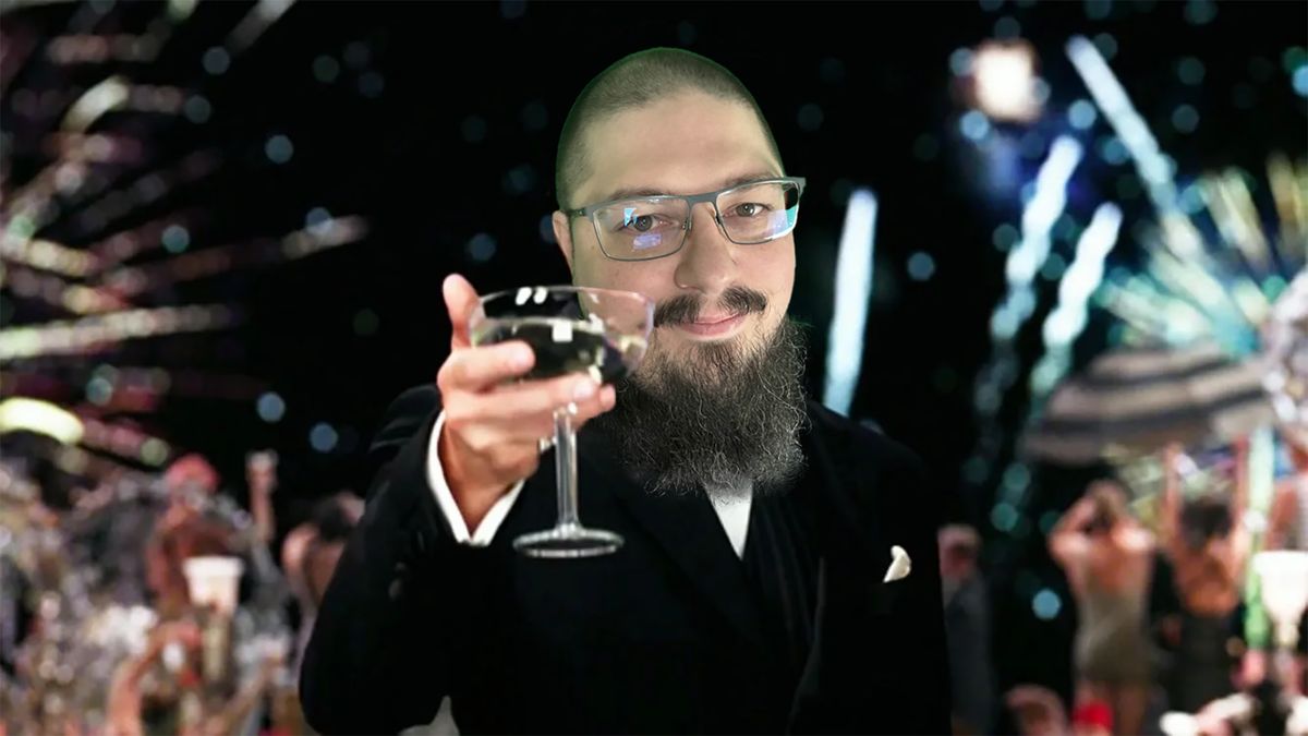 Sword in a dark suit raising a champagne glass toward the camera, fireworks behind him.